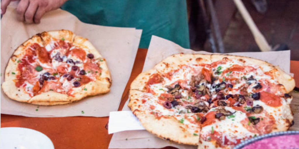 Deux pizzas présentes sur une table - Les Escapades à Rome