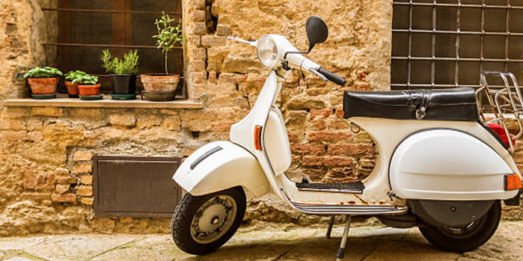 Vespa stationnée dans une rue - Les Escapades à Rome