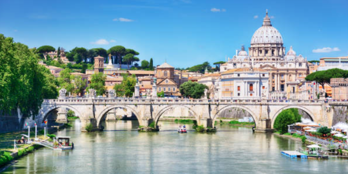 Un pont au dessus du Tibre avec la Basilique Saint-Pierre en arrière plan - Les Escapades à Rome